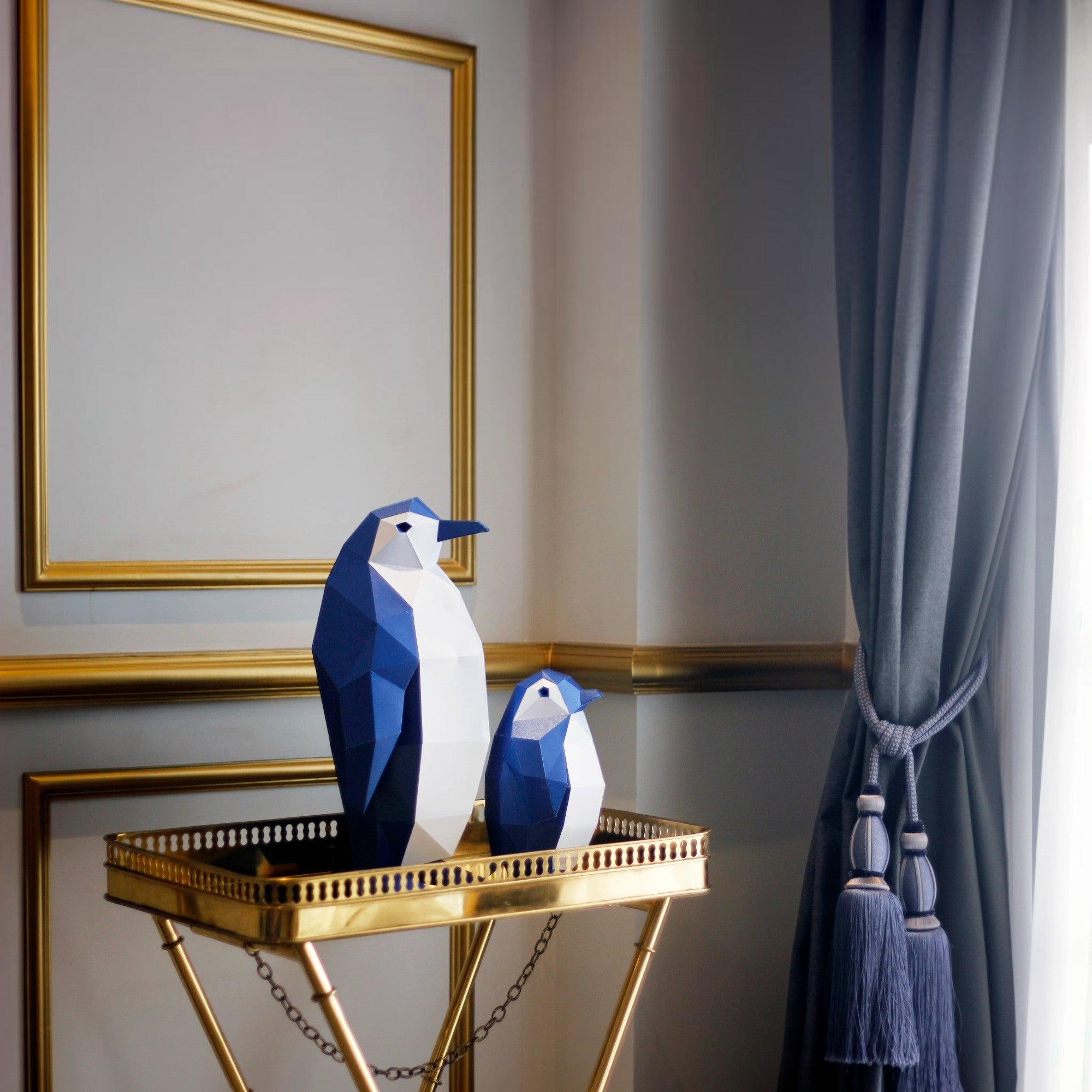 Penguroo® Gifts Inc. set of two geometric penguins, one large and one small, in blue and white faceted design, displayed on a gold tray.