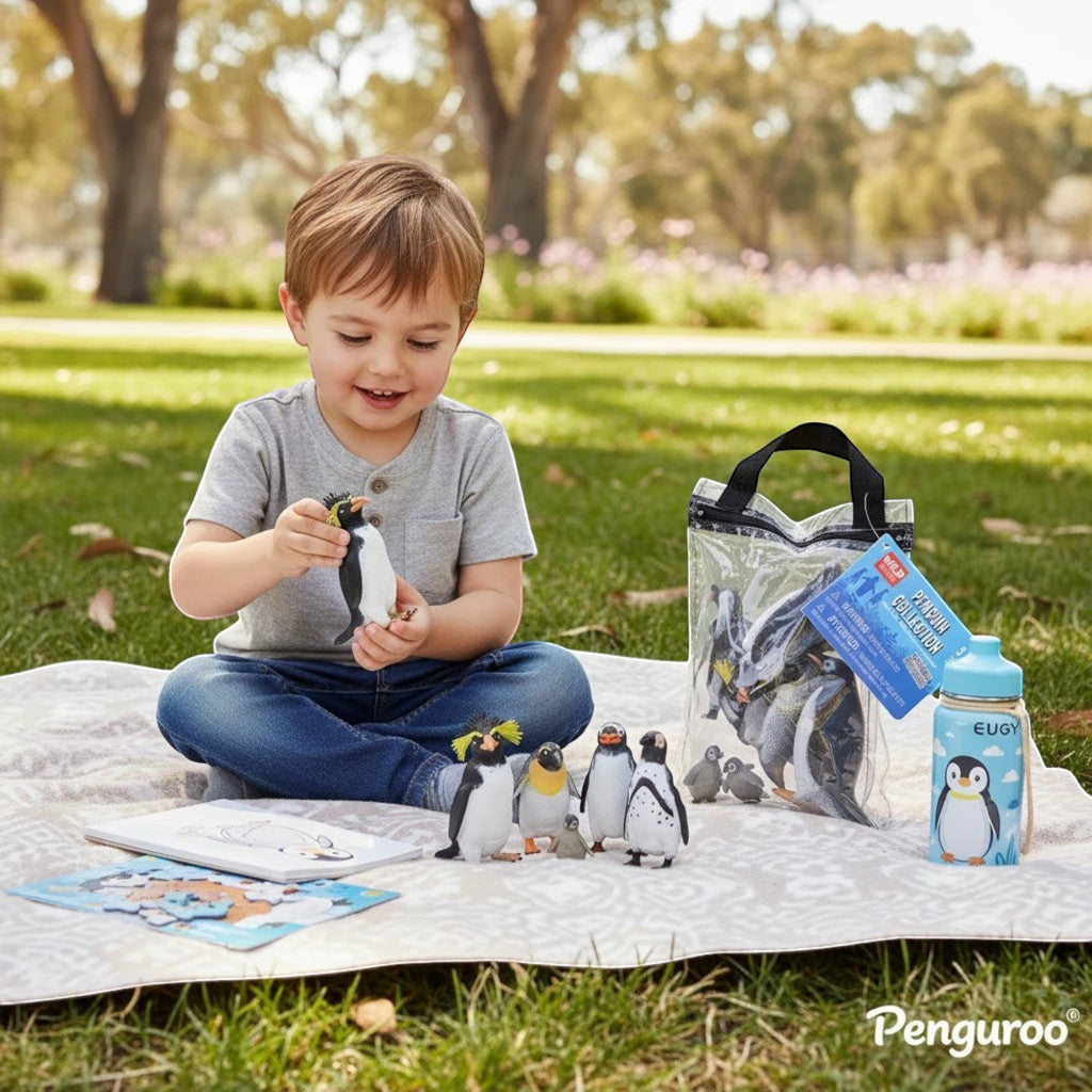 Penguroo® Gifts Inc. child playing with penguin toys on a blanket outdoors. Includes toy penguins, a water bottle, and a coloring book.